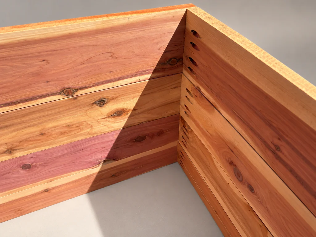 Close-up of an interior cedar corner with pocket-hole connections on the right panel.