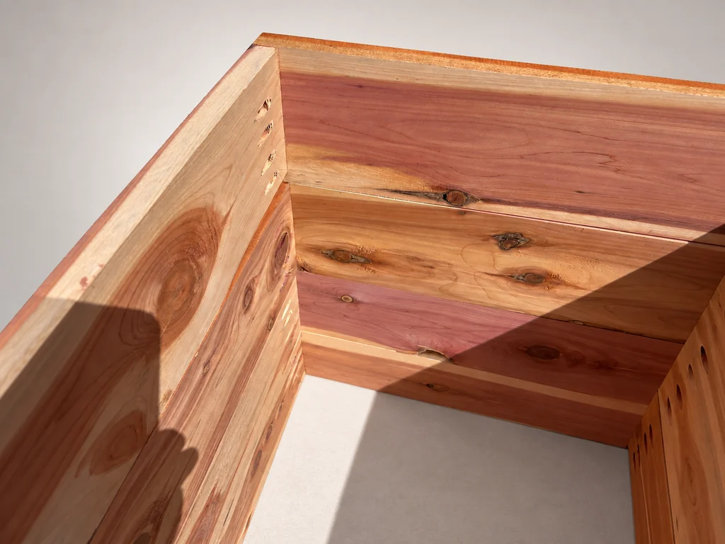 Opposite interior corner showing cedar grain, knots, and pocket-hole connections.